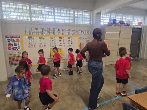 Grupo siguiendo el movimiento de la maestra en el salón