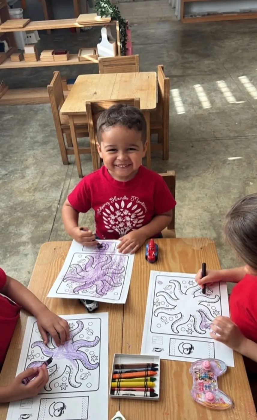 Niños coloreando juntos alrededor de una mesa