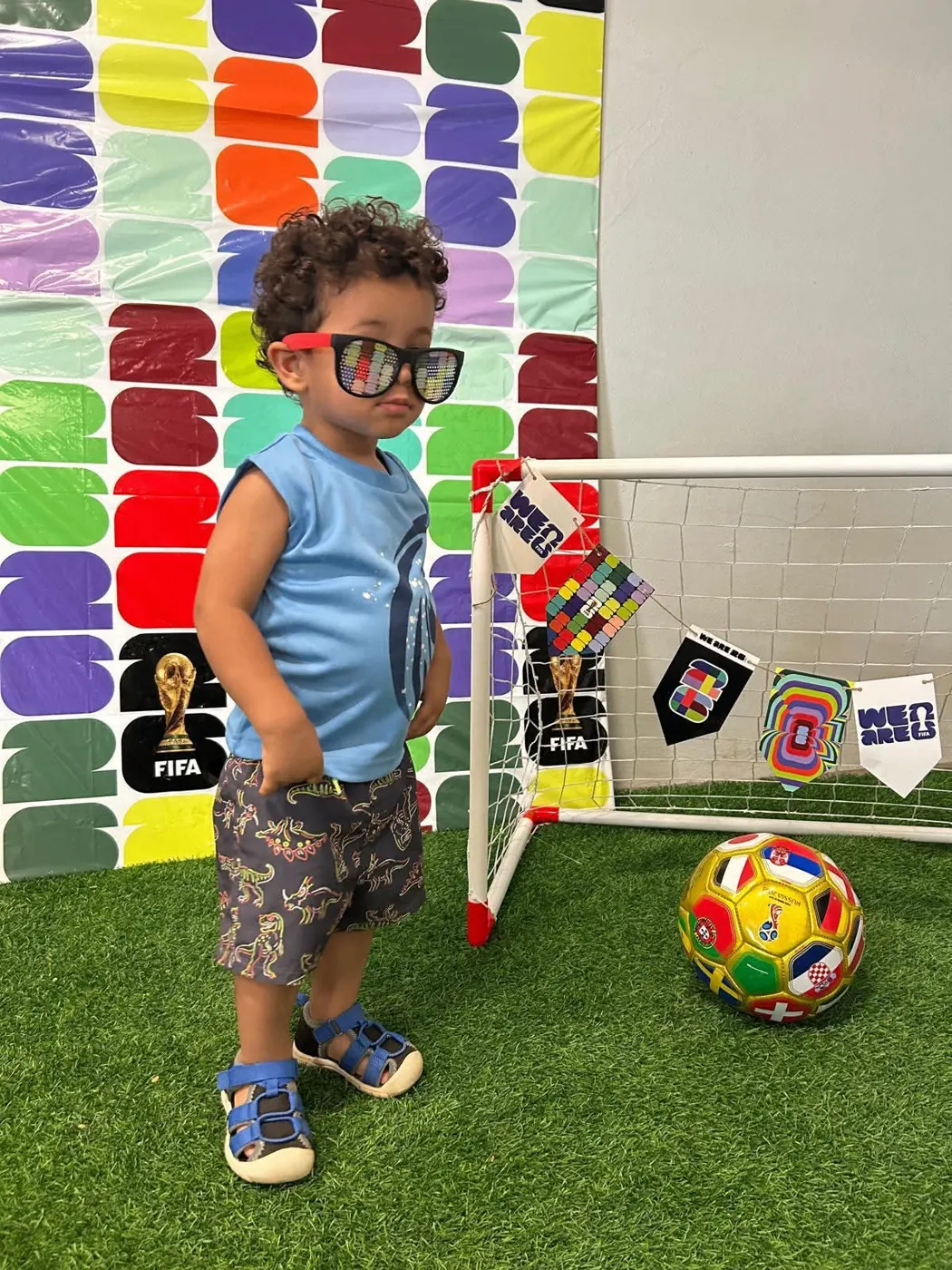 Niño con lentes de colores junto a la portería de fútbol