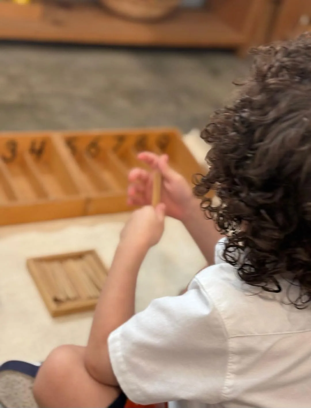 Niño trabajando con la caja de husos Montessori