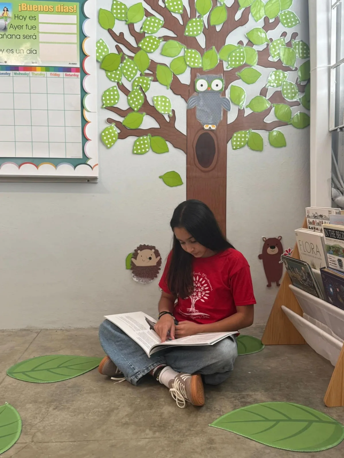 Estudiante concentrada leyendo bajo el árbol de lectura
